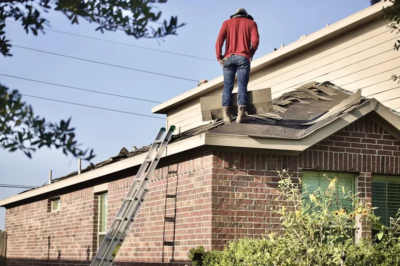 Professional roofer working on a residential roof in Ontwa